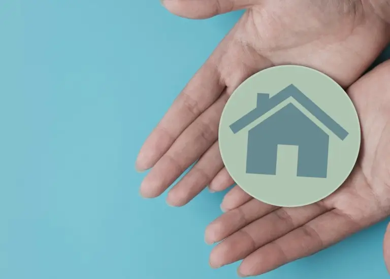 two hands holding a sticker with a house on it